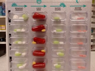 A large blister pack, with large transparent plastic pockets for four different types of medication. There are 7 rows of each medication and additional information printed above the blister pockets, including arrows to indicate the order in which to take each medication dose.