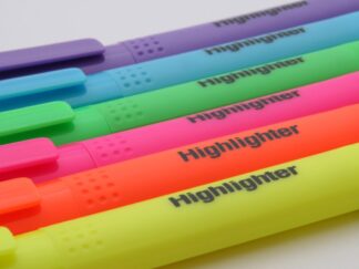 Six bright coloured highlighter pens are laid side by side, from purple, blue, green, pink, orange and yellow.